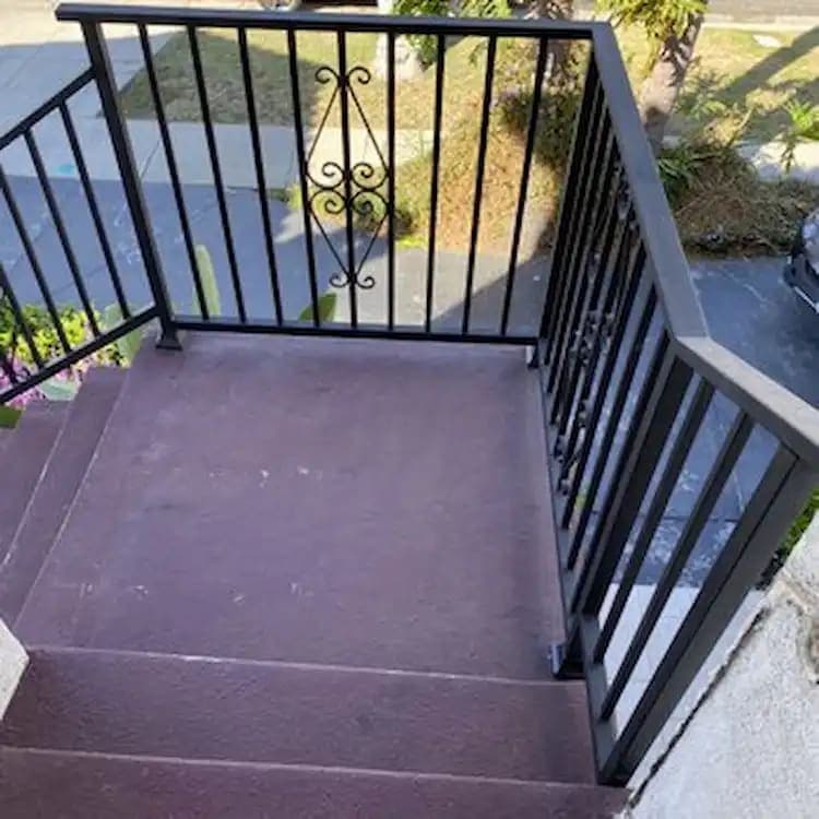 Black metal railing on an exterior landing and stair