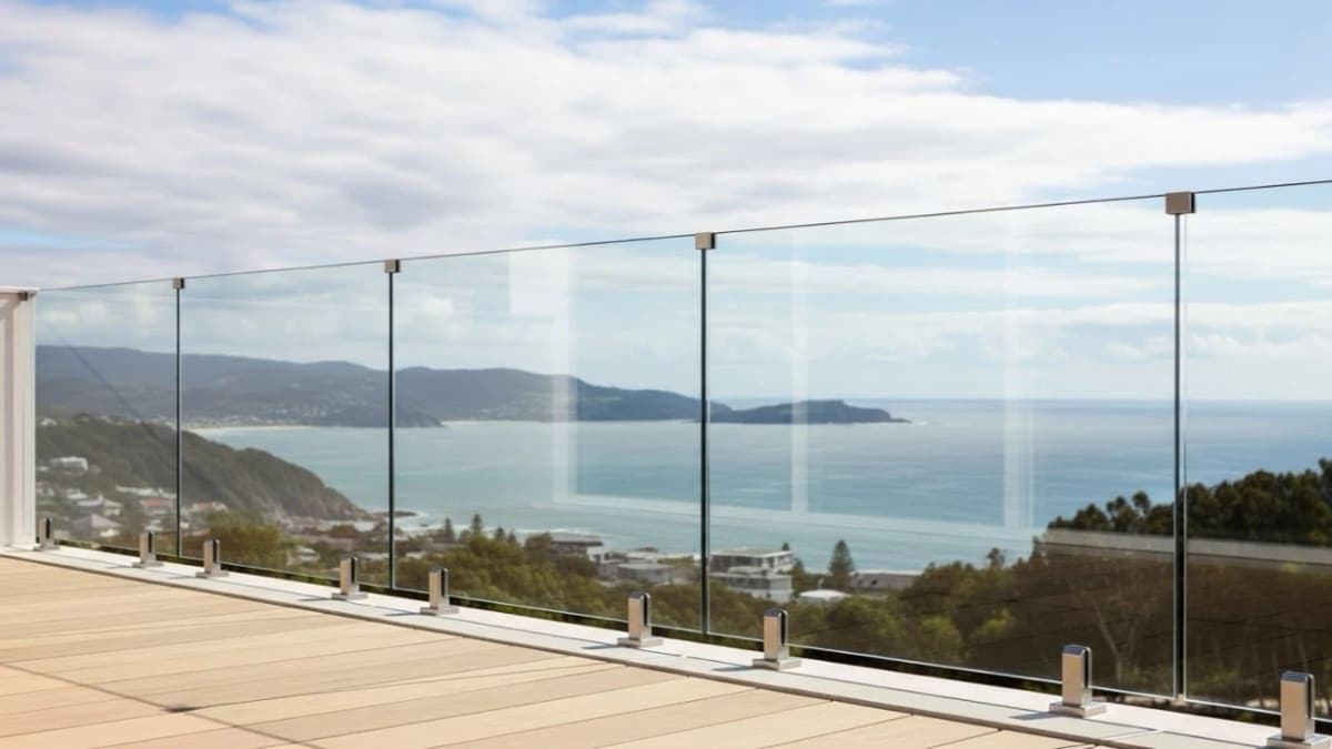 Frameless glass railing on top-mounted spigots along a deck
